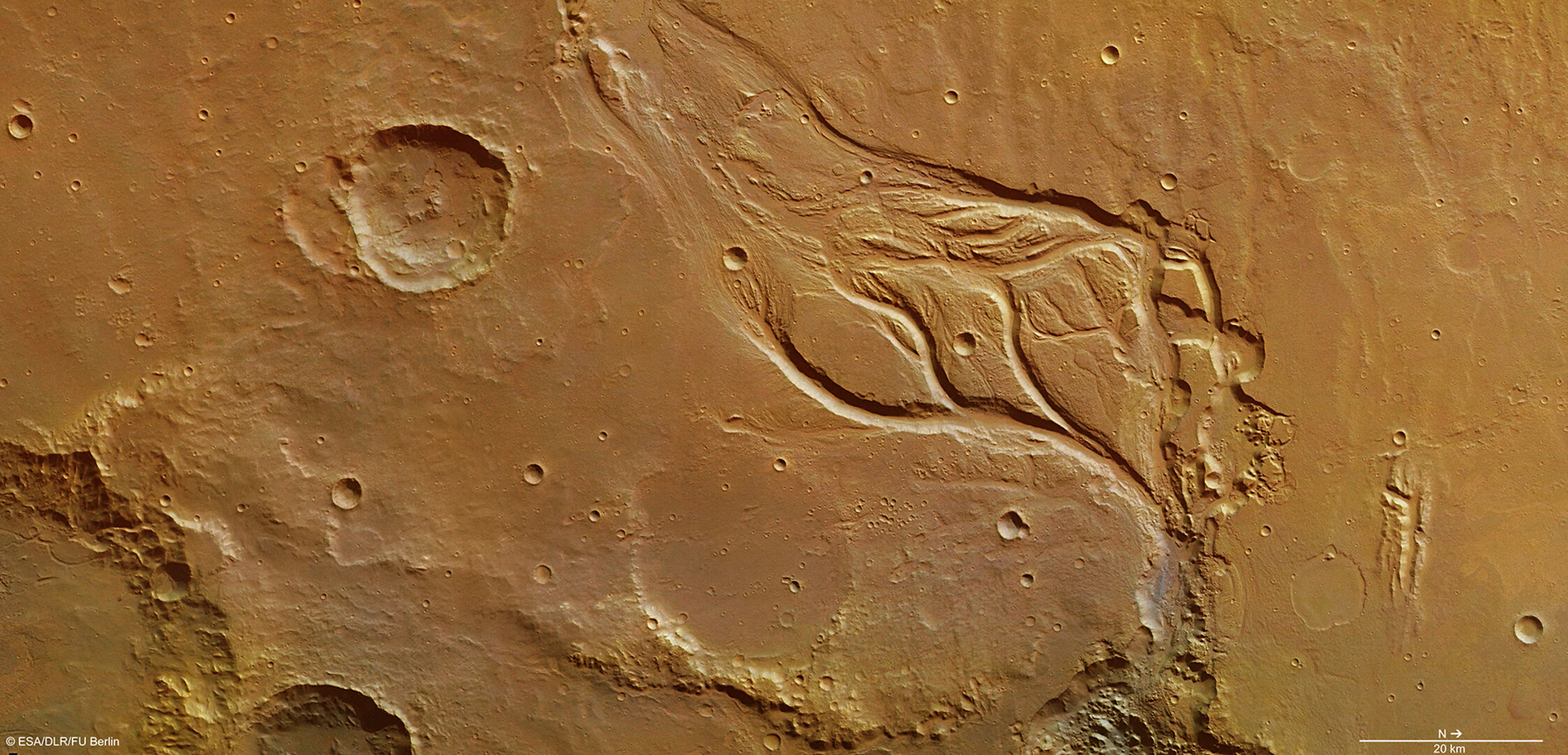 Fig. 2. Part central d'Osuga Valles al planeta Mart. Hom creu que inundacions catastròfiques van crear aquesta regió, molt erosionada, que mostra illes hidrodinàmiques i un sòl acanalat tallats per aigua que fluïa ràpidament (cap a la part inferior dreta de la imatge). Crèdits: ESA.