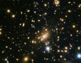 This image shows the huge galaxy cluster MACS J1149.5+223, whose light took over 5 billion years to reach us.  The huge mass of the cluster is bending the light from more distant objects. The light from these objects has been magnified and distorted due to gravitational lensing. The same effect is creating multiple images of the same distant objects.